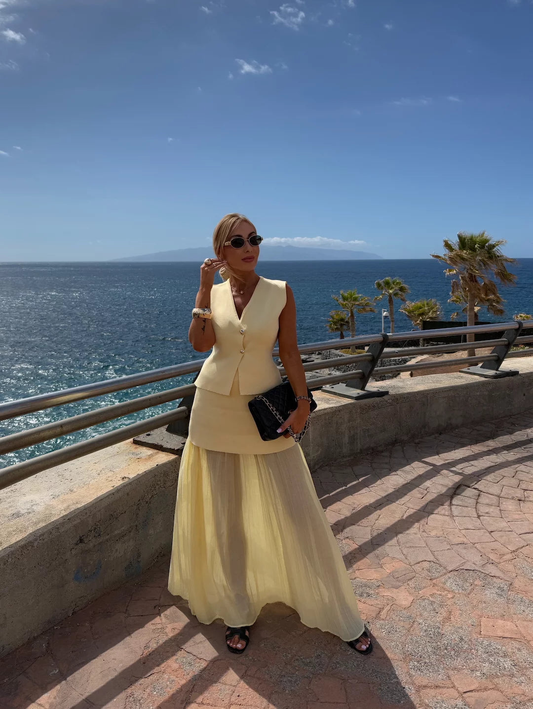 Tenue féminine chic avec jupe longue plissée et gilet à boutons